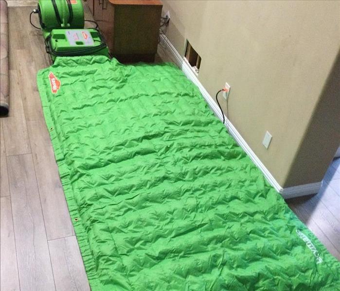 green blanket covering wooden flooring 