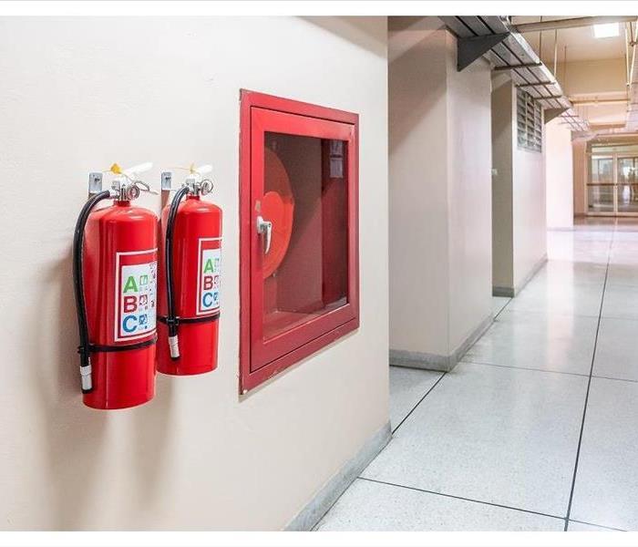 red fire extingusher on a white wall 